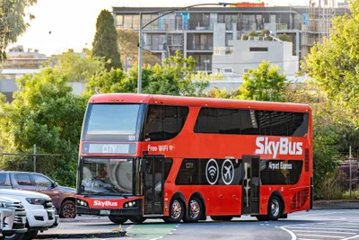 A red SkyBus double-decker on a city run, marked 'Airport Express'
