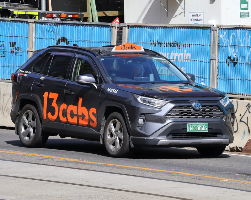 A Melbourne taxi — look for the roof sign and the green 'Accredited Taxi Service' number plate