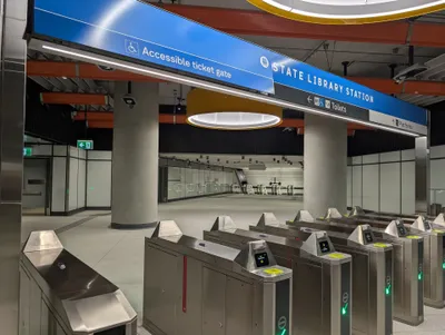 Fare gates at State Library Station — pick a gate showing a green tick and tap on the reader pad on top