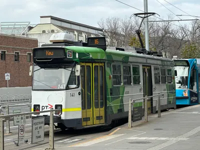 アンザック駅前の停留所に停まるトラム（2026年7月）。足元の標識は「歩行者はトラムに道を譲れ」