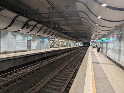 The platform at International Terminal station — INTERNATIONAL TERMINAL wall signs and green EXIT signs.