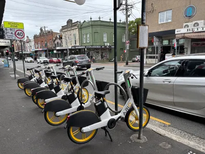 Ario e-bikes parked upright in a marked kerbside bay, clear of the footpath.