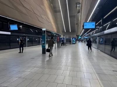 Metro platforms 26 and 27 at Central. Both edges are lined with platform screen doors — wait where they open.