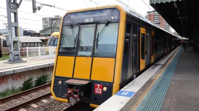 A Sydney Trains suburban service — yellow front end, double-deck cars.