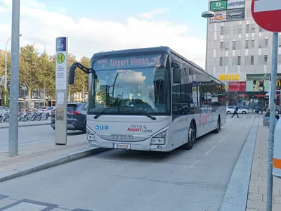 The airport bus (Vienna Airport Lines) at Westbahnhof; the stop pole carries the plane-and-bus pictogram.