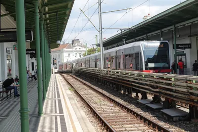 Nußdorfer Straße on the U6 — a surface platform under historic green ironwork, served by tram-like cars.