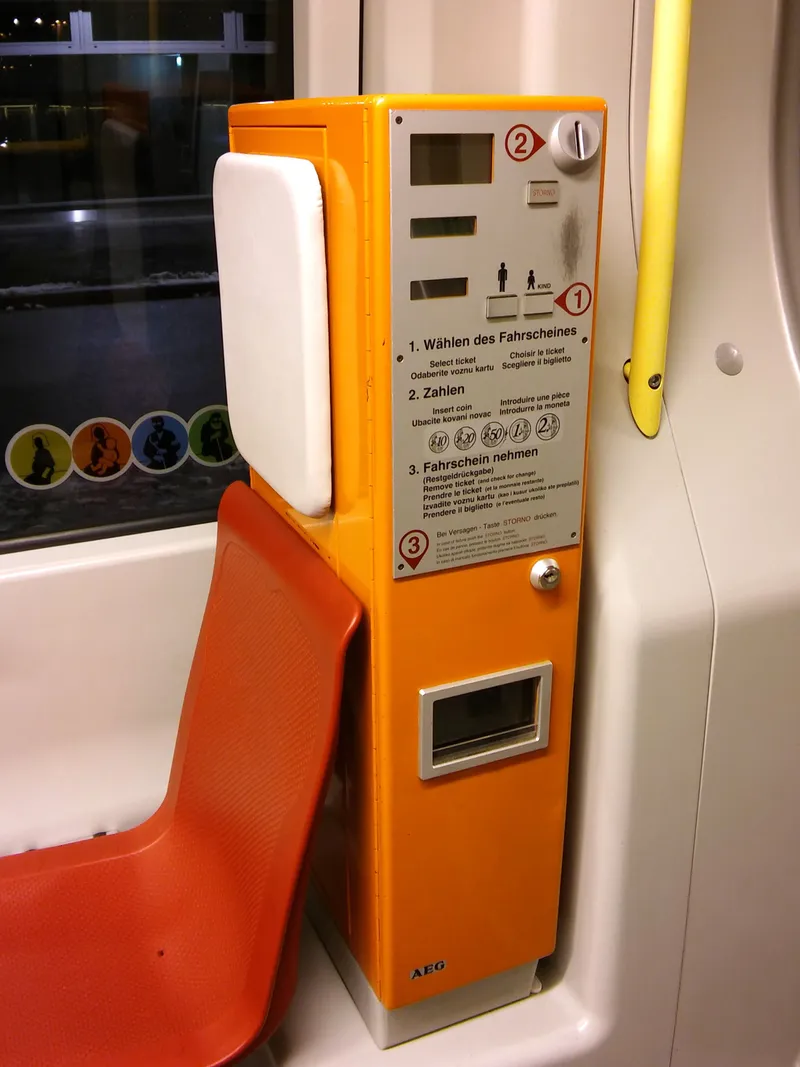 トラム車内のオレンジ色の券売機。硬貨のみで、券種を選び→コインを入れ→券を取る