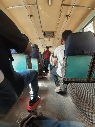 Inside a local bus — the aisle takes one person at a time and there is nowhere to put a large bag