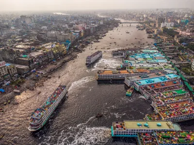 Sadarghat from the air during the Eid exodus — launches pulling out with passengers packed onto the upper decks