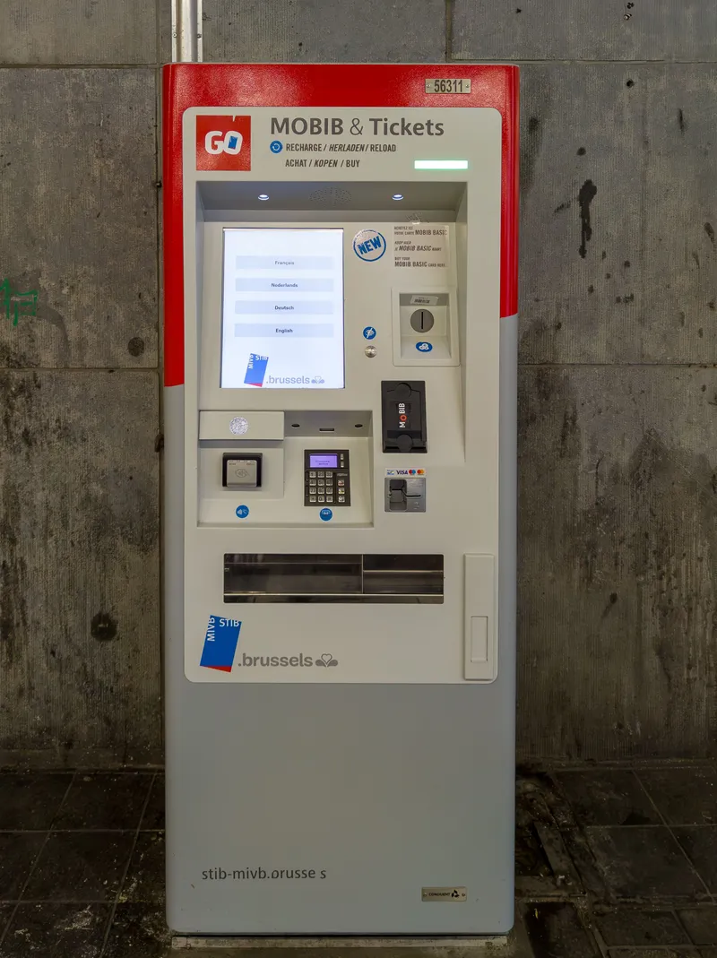 The red "GO" machine — the screen offers French, Dutch, German and English, with a coin slot and a card reader alongside.