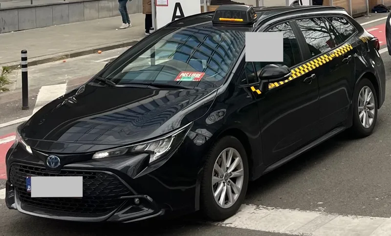 The yellow chequer on black marks a licensed Brussels taxi. The red card in the windscreen reads "PAS LIBRE" — not for hire.