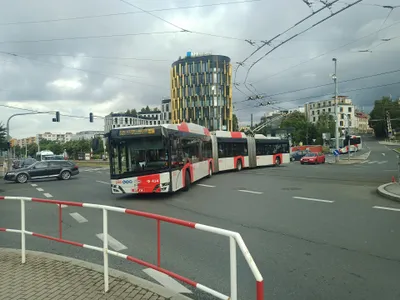 An articulated trolleybus pulling out of its stop, with the PID logo on the side