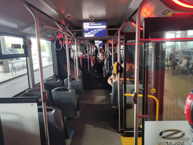Inside a line 59 trolleybus - the yellow validator sits on the pole mid-cabin. A paper ticket is stamped once, right after boarding.