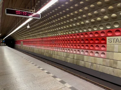 The platform at Staroměstská on line A, lined with walls of circular moulded metal panels