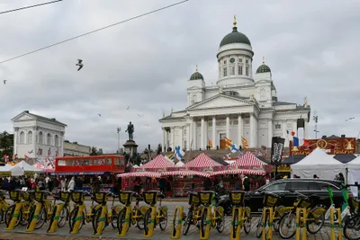 A city bike station in front of Helsinki Cathedral, the bikes locked into their yellow docking posts.