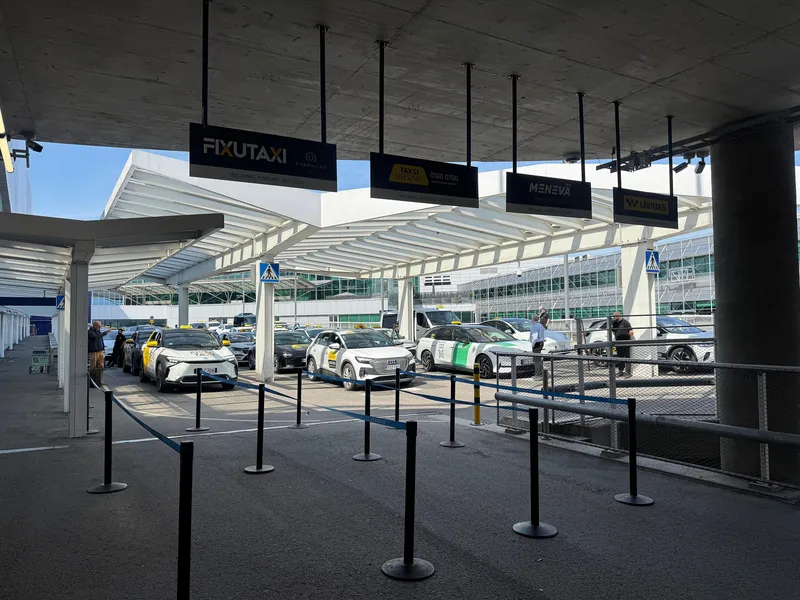 The taxi rank at Helsinki Airport: the four contracted companies (FixuTaxi, Taksi Helsinki, Menevä, Lähitaksi) each queue in their own lane.