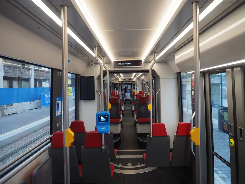 Inside a Helsinki tram — the blue card reader is mounted on a pole in the middle of the car.