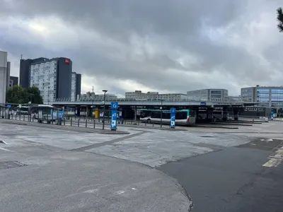 The bus station at Roissypôle, CDG — stands are lettered (G, F …) and a "Bus · Information · Tickets" office stands at the far end.