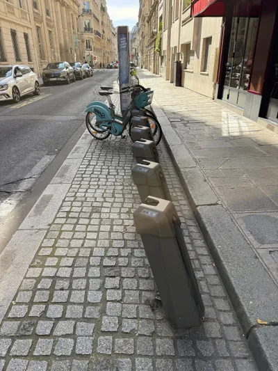 A row of empty docks — you push the front wheel into the slot to return a bike; each dock carries a number and small status lamps.