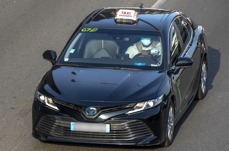 A licensed cab is identified by the roof sign "TAXI PARISIEN", with the A/B/C tariff letters on the strip below; the windscreen here carries the operator G7's logo.
