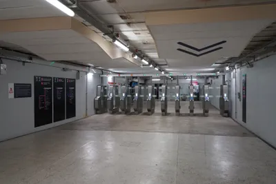 A line of validation gates (La Défense, Transilien) — hold your Navigo Easy card or phone to the reader in front of the doors.