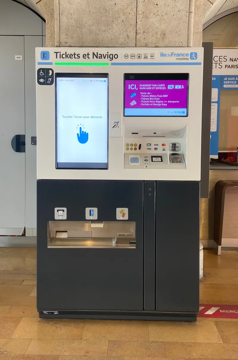 A current "Tickets et Navigo" machine — the side screen lists what it sells (métro/train/RER, bus/tram and airport tickets, plus Navigo Easy) and that it takes cards and cash for those purchases.