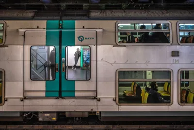 A double-deck RER A car — the doors do not open by themselves; press the round button or pull the recessed handle.