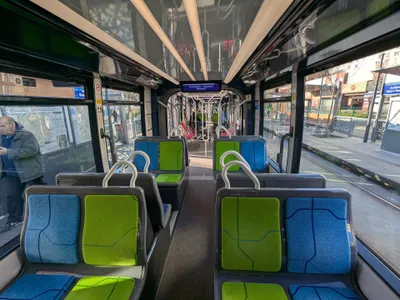 Inside a tram — the ceiling display carries the stop name (Asnières - Quatre Routes).