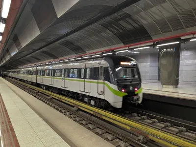 A metro train at the platform — white body with a lime-green band
