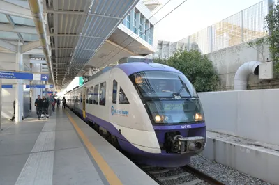 A suburban train at the airport station showing "ANO LIOSSIA" — this one does not carry on into the city centre