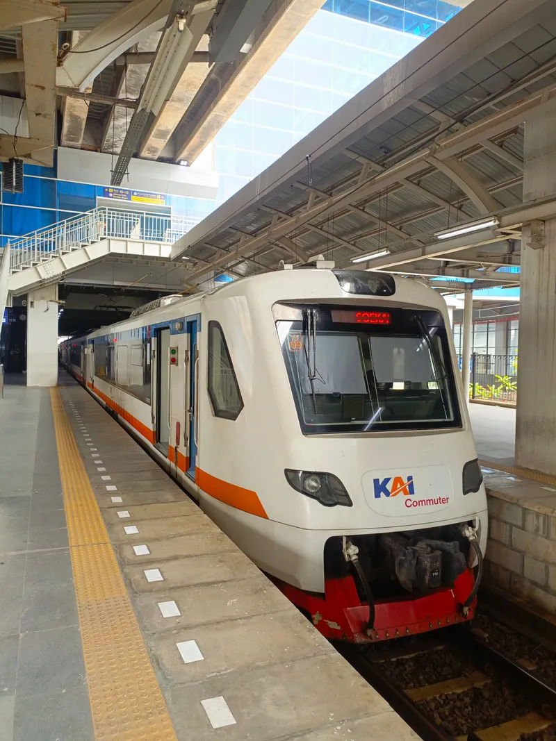 The airport train at Manggarai: white and orange, with the KAI Commuter mark