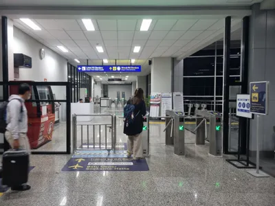 The transfer at Manggarai: signs to the airport train ticket counter and its entrance