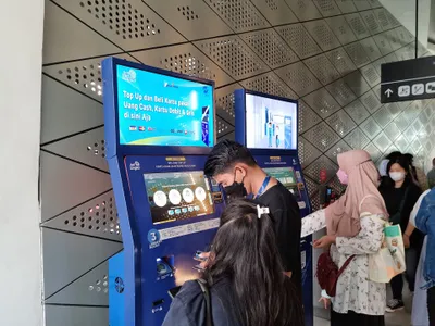 The JakLingko machine at a halte entrance sells e-money cards and tops them up; cash accepted