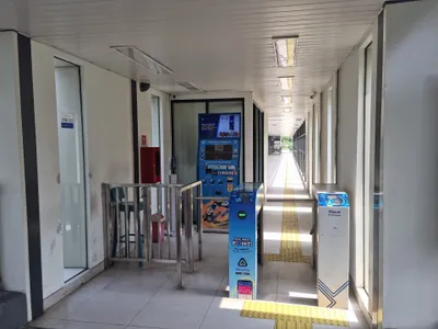 A halte entrance: ticket machine on the left, the Masuk (entry) turnstile on the right