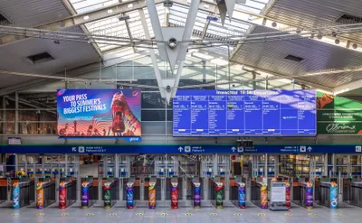 The gateline at Dublin Connolly. Each gate has a reader on its top surface, and the board above splits departures by direction - 'DART o Thuaidh / DART North' and so on.