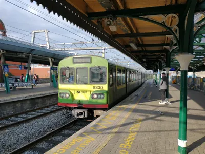 A DART train - green and yellow, with the arrow-marked 'DART' logo on the front.
