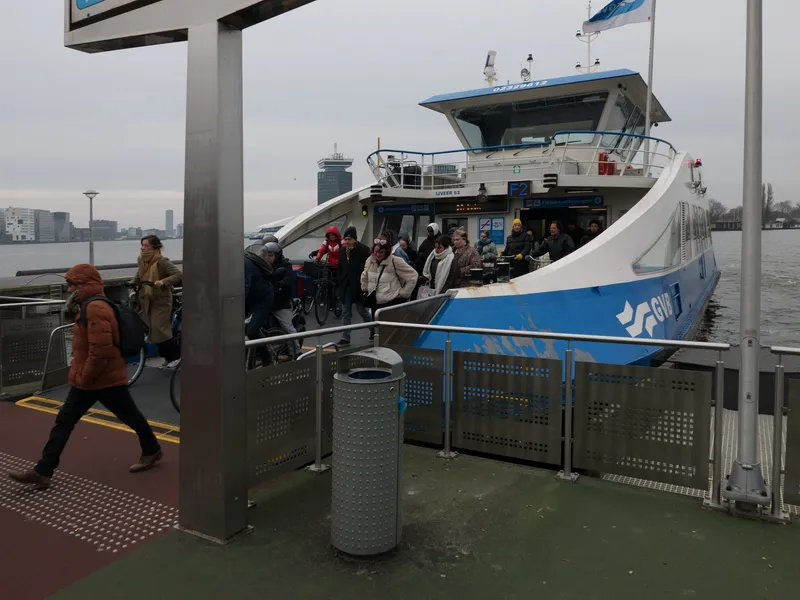 Ferry F2 at the landing behind Amsterdam Centraal. There are no gates and no card readers - when the ramp drops, people and bicycles simply walk off.