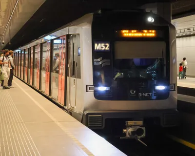 A line 52 train pulling into the underground platform at Amsterdam Centraal; the line number shows on the front.