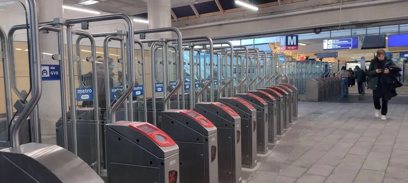 Metro fare gates at Amsterdam Zuid. The reader sits in the red top of each gate - that is where you tap your card or phone.