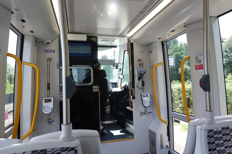 Inside a GVB tram: tap the white reader on the pole twice - once when you board and once when you get off.