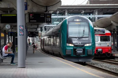 Vy local and regional trains. Two liveries run side by side - the teal newer units and the older red-and-white ones (right) - so the VY mark on the front, not the colour, is what identifies them. The display above shows line, destination, time and track.