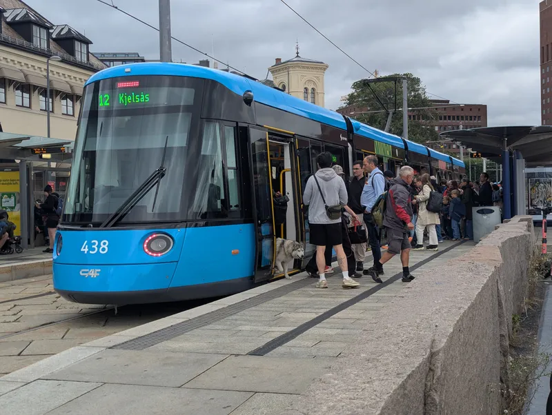 A tram with its doors open at a stop. There are no gates - you board with the ticket you already have.