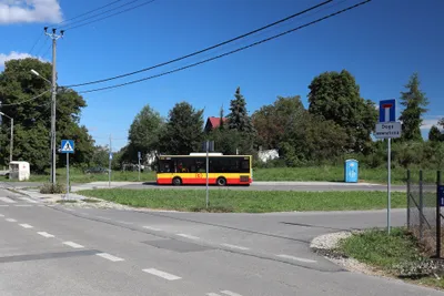A city bus waiting at a terminus. The red-and-yellow bands, with the red "t" roundel on the yellow one, are the city transport livery.