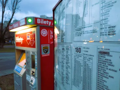 A free-standing ticket machine beside a stop: look for the red box lettered "Bilety" (tickets). Buy here before you board.