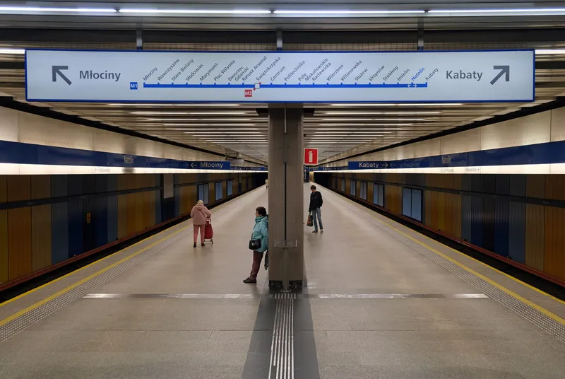 Direction sign on the platform at Natolin: the whole M1 line on one strip, with the M2 interchange marked at Świętokrzyska.