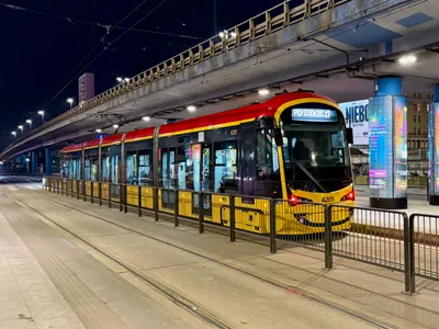 A current-generation tram at the stop by Warsaw Central Station. Red and yellow is the city transport livery.