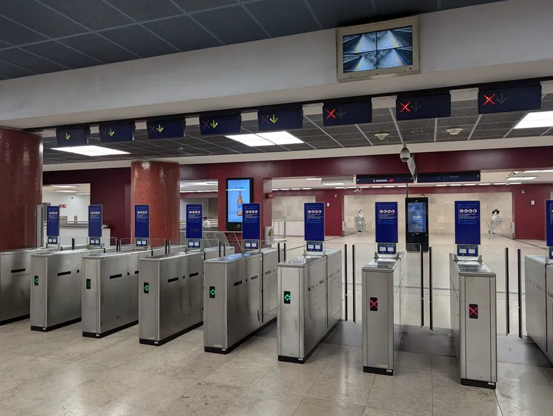 Fare gates at the airport station. The blue signs say that large items, prams and adults with children under four should not use these gates but the wide "canal especial" instead.
