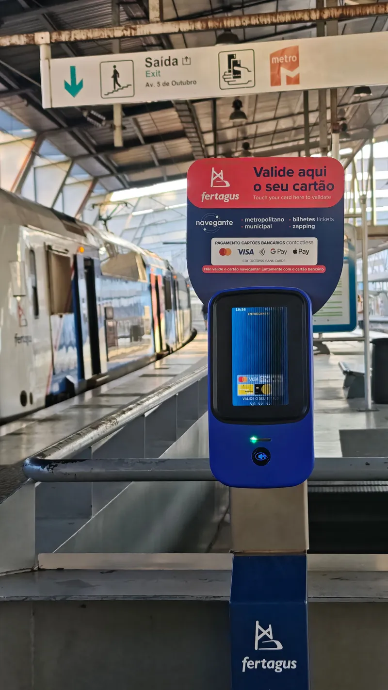 A Fertagus validator on the platform at Entrecampos. It accepts navegante cards plus contactless Mastercard, Visa, Google Pay and Apple Pay, and warns you not to present a navegante card and a bank card together.