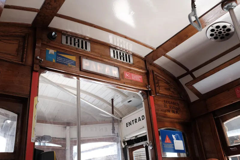 Inside a Lisbon tram: no-smoking and pickpocket warnings are posted above the door, and the woodwork is lettered with the capacity - 20 seated, 38 standing.