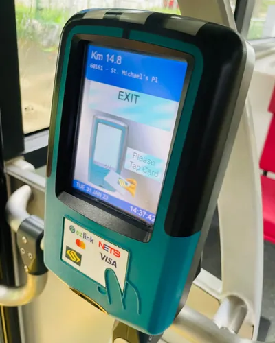 The reader you tap when getting off — the screen reads EXIT / Please Tap Card, with ez-link, NETS, Mastercard and Visa marks below